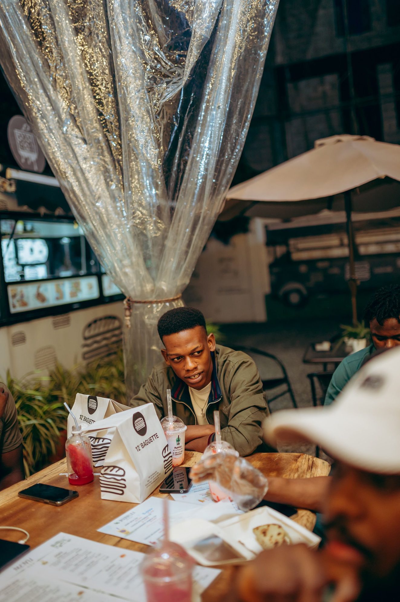 Ayobami at a café table, looking to one side